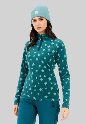Teal fleece pullover met een kwart-rits, voorzien van een sterpatroon in lichtblauw. Gecombineerd met een bijpassende teal gebreide beanie.