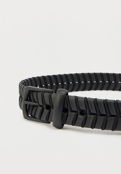 Μαύρη υφασμάτινη ζώνη με υφαντό μοτίβο και μαύρη ματ αγκράφα, που συνδυάζει υφασμάτινα και πλαστικά υλικά.