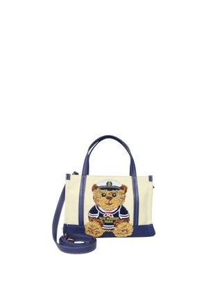 Borsa beige e blu navy con manici blu e tracolla staccabile, con un orsetto ricamato sulla parte anteriore che indossa un abito da marinaio.
