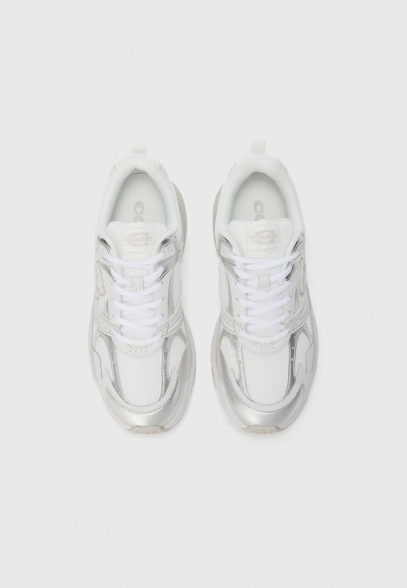 White sneakers with silver accents, mesh and synthetic materials, round toe, padded tongue, and lace closure. Detailed with logo embossing.