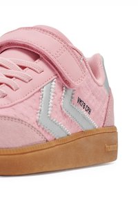 Różowy sneaker z paskiem na rzep, posiadający teksturowany wierzch, szare akcenty, gumową podeszwę oraz napis "VN78 CPH" po boku.