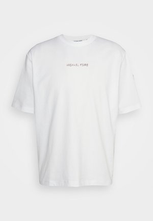 Bijela pamučna majica s kratkim rukavima, okruglim izrezom i centriranim logotipom "MICHAEL KORS" u metalnoj niti.