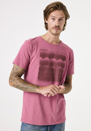 T-shirt à manches courtes et col rond en framboise chinée avec un design graphique contrastant en rouge foncé, comprenant des lignes ondulées et des détails textuels.