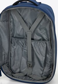 Blauwe rugzakinterieur, met grijze stofvoering, een elastische zak en verstelbare banden om de inhoud te beveiligen. Overal een gladde textuur.