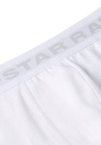 Weiße Boxer-Briefs aus weichem Baumwollmaterial, ausgestattet mit einem breiten elastischen Bund in hellgrauer Schrift und einem glatten, nahtlosen Design.