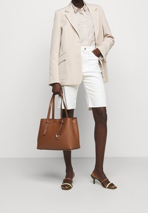 Ruskea nahkainen olkalaukku, jossa on kaksinkertaiset kahvat, hopeinen yksityiskohta ja jämäkkä muotoilu. Yhdistetty beigen väriseen bleiseriin, vaaleaan paitaan ja valkoisiin shortsihousuihin.