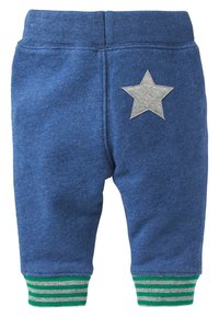 Blå sweatpants med gröna och vita randiga muddar, prydda med ett grått stjärnpatch på baksidan, tillverkade av mjuk, texturerad bomull. 