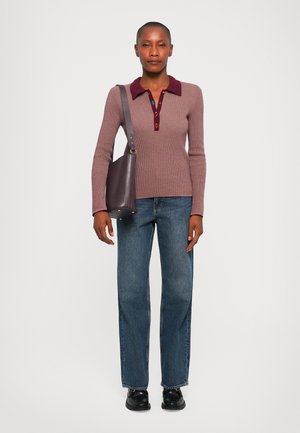 Knitted burgundy polo sweater with a textured finish, paired with relaxed blue jeans and a dark purple shoulder bag. Black shoes.