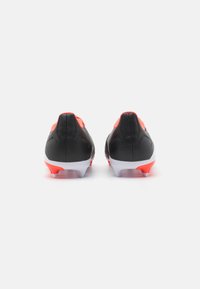Scarpe da calcio nere e rosse con un design elegante, superficie testurizzata, suola bianca e tacchetti multicolori per la trazione.