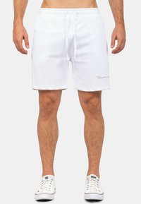 Witte katoen shorts met een elastische taille en trekkoord. Voorzien van zijzakken en een minimalistisch logo op de zoom. Casual fit.