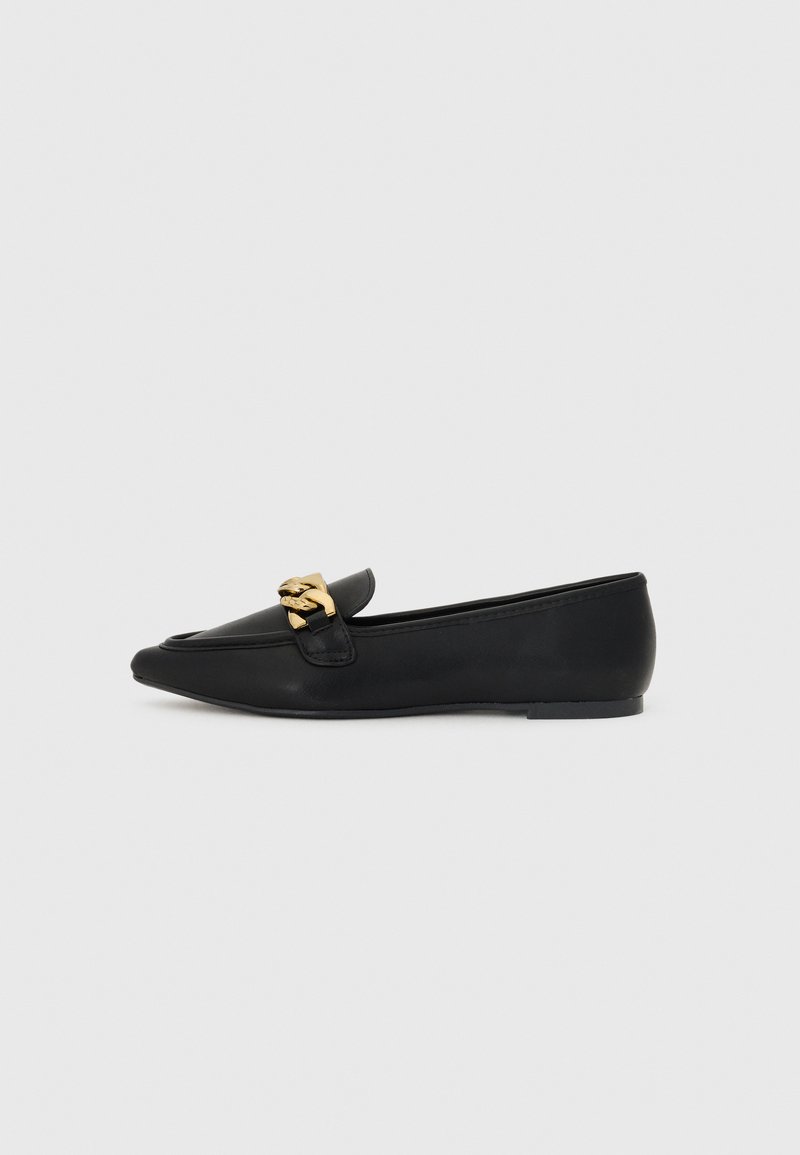 Svarte skinnloafers med spiss tå, med en dekorativ gullkjedeakzent foran og flat såle. Minimalistisk design.