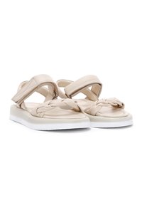 Beige sandalen met een gevlochten ontwerp, brede kruisbanden en een witte rubberen zool, met een gladde lederen textuur.