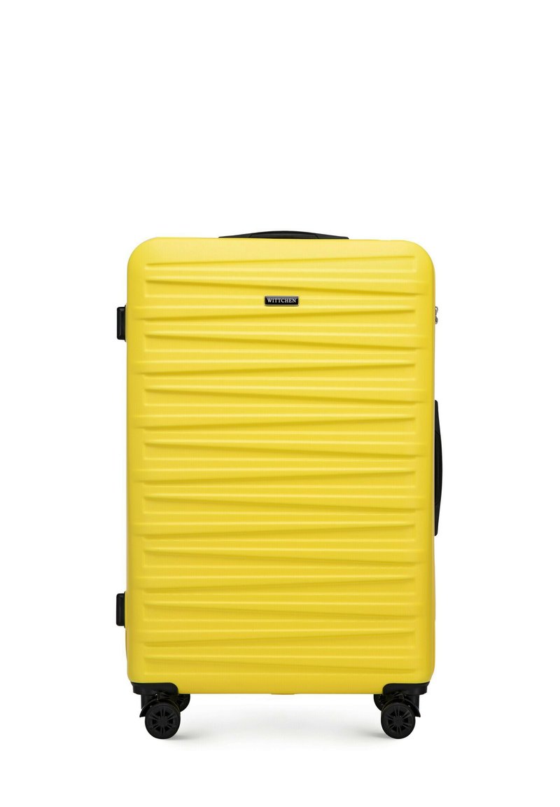 Hard-shell gele koffer met horizontale ribbelstructuur, uitschuifbare handgreep en vier wielen voor mobiliteit. Merkenlogo gecentreerd aan de voorkant.