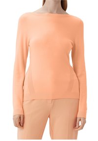 Pull à manches longues couleur pêche clair avec encolure bateau. Comprend des accents côtelés et une texture lisse, associé à un pantalon assorti de couleur pêche clair.