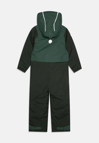 Zaļš ūdensnecaurlaidīgs kombinezonis ar odere izklātu kapuci, elastīgiem aprocēm un velcro aizdari potītēs. Aizmugurē ir atstarojošs logotips.