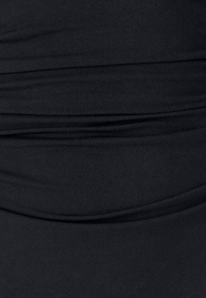 Czarny materiał o miękkiej fakturze, z marszczeniami i gładkimi liniami, tworzący warstwowy wygląd bez wzorów czy ozdób.