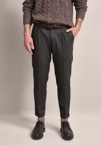 Gray patterned trousers with a tailored fit, paired with a brown textured sweater and dark shoes. Includes a brown leather belt.