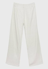 Wijdvallende broek in lichtbeige, gemaakt van zachte stof, met een vlakke voorkant, riemlussen en zonder zichtbare zakken of versieringen.