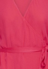 Robe portefeuille rouge avec décolleté en V et ceinture à nouer sur le côté, en tissu texturé.