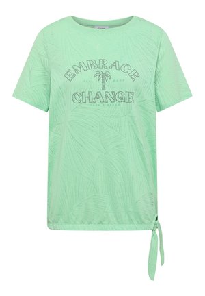 Camicia verde menta a maniche corte con motivo foglie sottile, scritta in strass "Embrace Change" e dettaglio annodato sul davanti a destra nell'orlo.