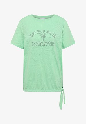 Camicia verde menta a maniche corte con motivo foglie sottile, scritta in strass "Embrace Change" e dettaglio annodato sul davanti a destra nell'orlo.