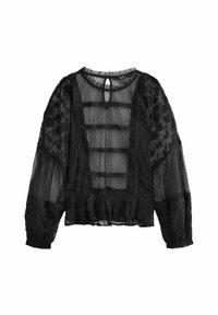 Sort gennemsigtig bluse med lange ærmer, blomsterløsning, prikket tekstur og en flæse i kanten. Nøgne hul lukning bagpå fuldender designet.
