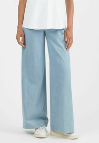 Light blue wide-leg pants made of soft fabric, featuring a loose fit and a smooth texture, paired with white sneakers.