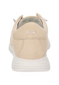 Baskets en daim beige avec un dos arrondi, semelle en caoutchouc blanche et broderie discrète du logo en argent. Équipées de lacets élastiques pour un enfilage facile.