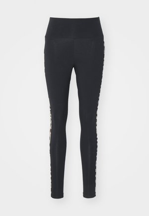  svarte leggings med høy midje, som har et mønster på sidene i nøytrale farger. Glatt tekstur, tettsittende design som ender ved anklene.