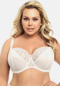 Witte bh met kantafwerking, voorzien van beugelsteun, voorgevormde cups en een satijnen afwerking. Kenmerken zijn een strik in het midden en decoratieve stiksels.