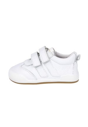 Zapatilla blanca de piel con dos correas de Velcro, punta redondeada, lados texturizados y suela de goma. La parte trasera presenta un pequeño lazo para facilitar el calzado.