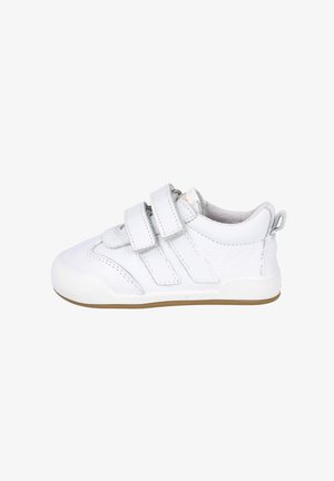 Zapatilla blanca de piel con dos correas de Velcro, punta redondeada, lados texturizados y suela de goma. La parte trasera presenta un pequeño lazo para facilitar el calzado.