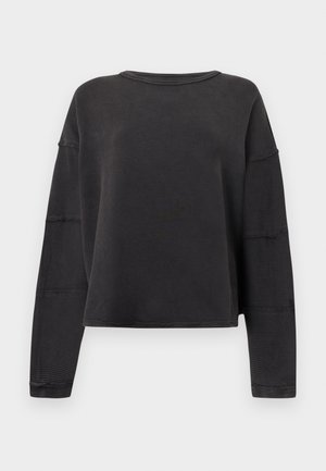 Μαύρο μακρυμάνικο τοπ με κουτί κοπής, ριμπ υφή και στρογγυλή λαιμόκοψη. Διαθέτει κατεβασμένους ώμους και ακατέργαστες άκρες για μια χαλαρή σχεδίαση.