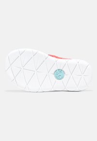 Sko yttersula i vit gummi med ett geometriskt mönster. Har en cirkulär blå logotyp nära mitten. En livlig korallröd överkant synlig.