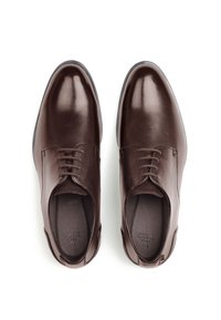 Braune Lederschuhe mit polierter Oberfläche, Schnürdesign, abgerundeter Spitze und einer strukturierten Innensohle. Schwarze Gummisohle für besseren Grip.