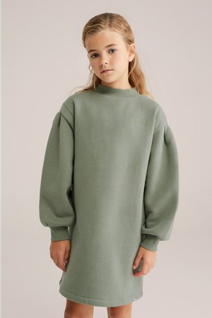 Roheline, suurenenud sviitdress koos puff-sleeve'idega, ribaga kaelusega ja pehme tekstuuriga. Omab tikandid teksti rinnal.