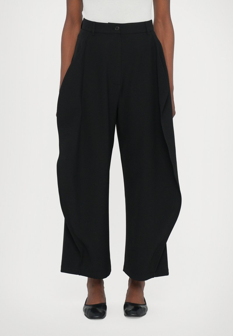 Black wide-leg trousers featuring a high waist, front pleats, and side pockets, made from a smooth fabric with a tailored fit.