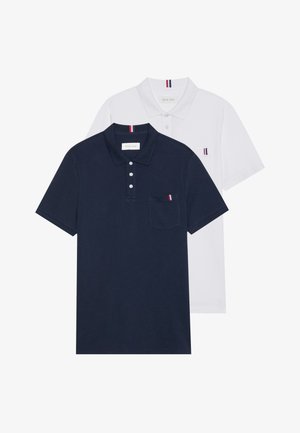 Two polo shirts: one navy blue and one white, both with a small red, white, and blue accent on the chest pocket and collar.