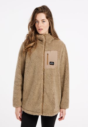 Veste en polaire de couleur brun clair avec fermeture éclair à l'avant, col montant et poche sur la poitrine. Caractéristiques en tissu doux et texturé, avec un patch logo.