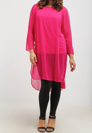 Long pink chiffon tunic with three-quarter sleeves, high-low hem, worn over black leggings and sandals. Smooth texture, lightweight fabric.