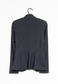 Veston bleu marine foncé à fines rayures, coupe cintrée, doté d'une fente unique, de revers crantés et de quatre boutons sur chaque manches. Suspendu à un crochet.