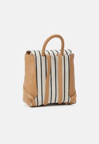 Striped fabric bag with tan leather accents, featuring a braided handle and a compact rectangular shape. Horizontal black and white stripes.