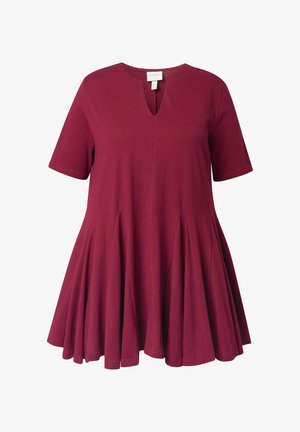 Bordeaux tuniekjurk van zacht materiaal, met korte mouwen en een V-hals. Bevat plooien vanaf de taille, wat zorgt voor een uitlopende silhouet.