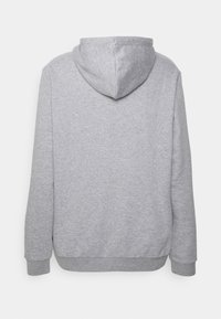 Felpa grigia con tessuto morbido e testurizzato. Presenta un cappuccio e polsini a costine. Il design è semplice, senza loghi o motivi visibili.