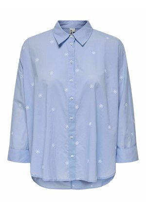Camisa azul clara abotonada con mangas largas y pequeños bordados de flores blancas dispersos por la tela.