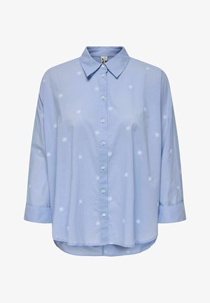 Chemise boutonnée bleu clair à manches longues avec de petites broderies blanches en forme de fleurs dispersées sur le tissu.