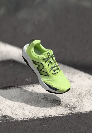 Neon green running shoe with a textured mesh upper, black detailing, and a white speckled sole. Features reinforced toe protection.