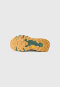 Brown rubber outsole with a textured pattern, featuring green accents and a yellow Vibram logo, designed for traction and durability.
