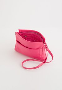 Růžová kožená kabelka přes rameno s elegantním obdélníkovým tvarem, přední klapkou a vnitřní kapsou na zip. Obsahuje tenký, nastavovací popruh.
