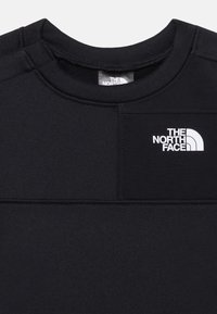 Sweat-shirt noir avec un col ras du cou, en tissu texturé, et un logo blanc sur la poitrine. Présente des détails de couture de panneaux contrastants.
